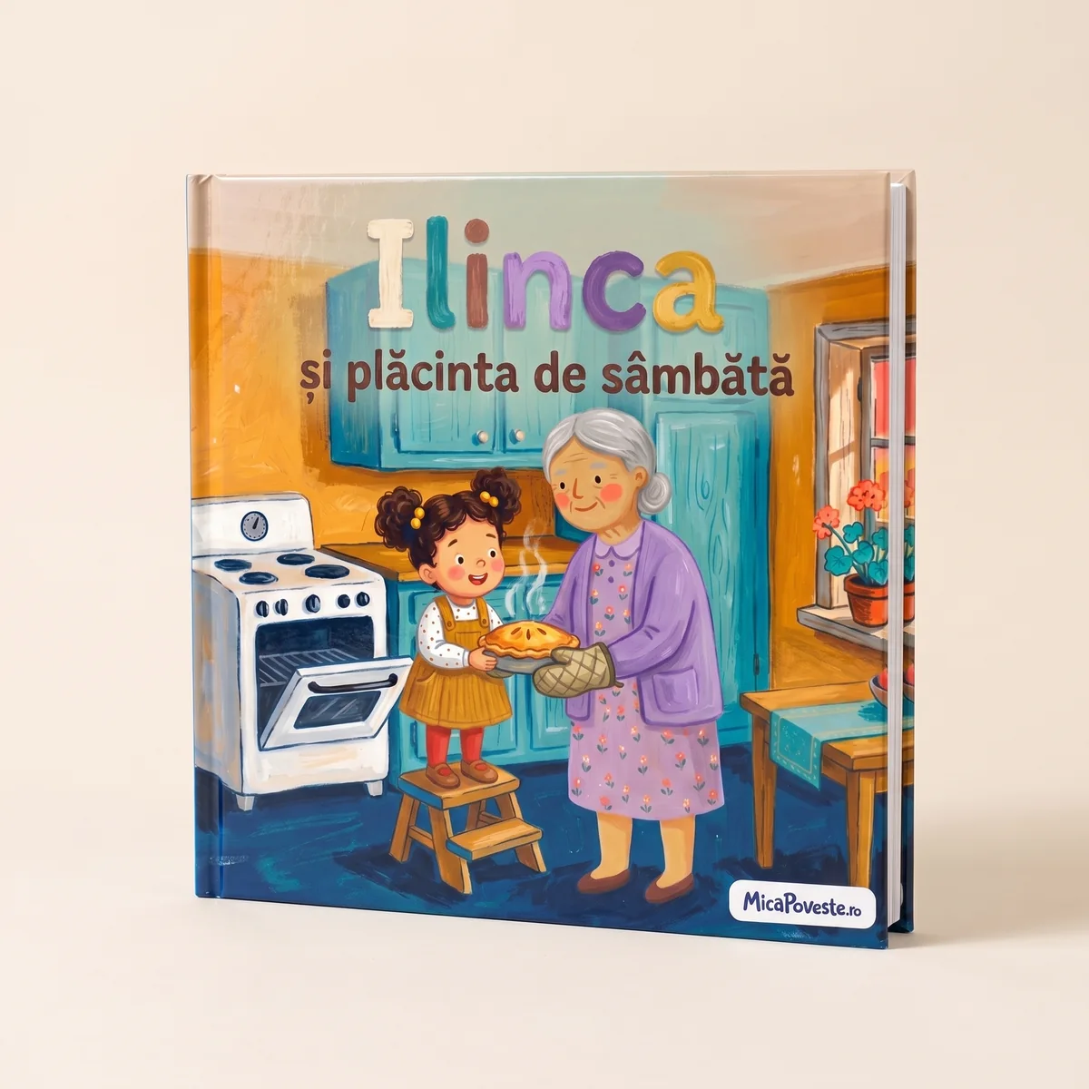 Cartea „Ilinca și plăcinta de sâmbătă”, cu copertă tare: pe copertă, o fetiță ține o plăcintă caldă lângă bunica ei, în bucătărie